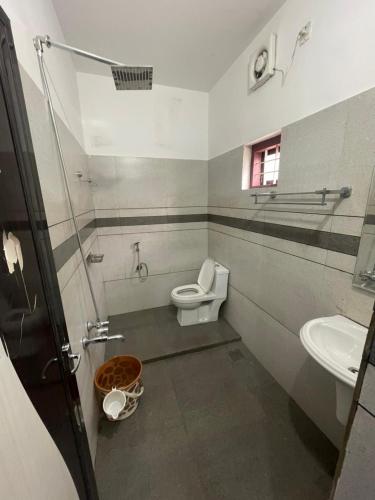 a bathroom with a toilet and a sink at Edakkal Pool Villa in Ambalavayal