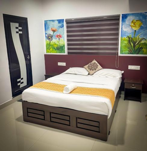 a bed in a bedroom with a painting on the wall at Edakkal Pool Villa in Ambalavayal