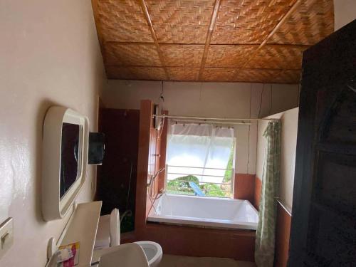 a bathroom with a bath tub and a window at Pulangbato Falls Mountain Resort in Dumaguete