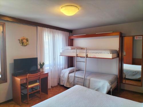 a bedroom with two bunk beds and a television at Hotel Monte Fior in Foza