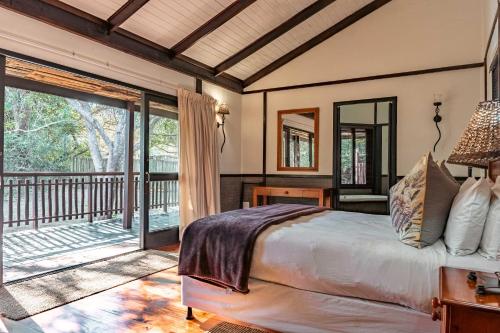 a bedroom with a bed and a balcony at Umthiba Bush Lodge in KwaNibela