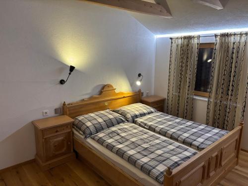 a bedroom with a bed with a wooden headboard and a window at Ferienwohnung Philipp in Leutasch