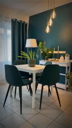 Chez Vous & Moi في Pavillons-sous-Bois: غرفة طعام بها طاولة وكرسيان