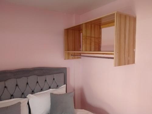 a bedroom with a bed and a wooden cabinet at Masqani studios muthiga in Rungiri