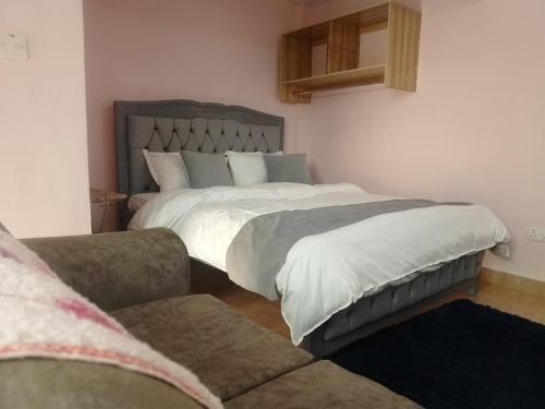 a bedroom with a large bed and a couch at Masqani studios muthiga in Rungiri