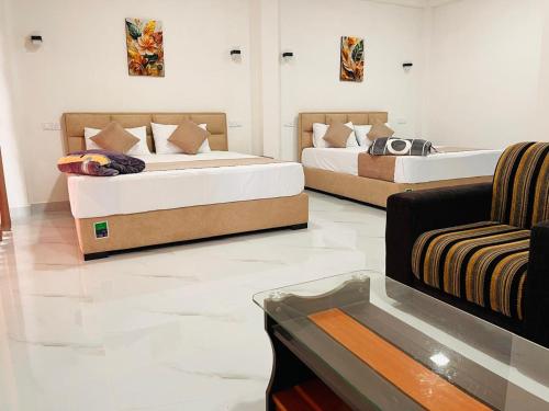 a room with two beds and a couch in it at Diyon'S Lodge in Ella