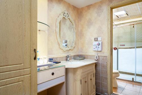a bathroom with a sink and a mirror and a toilet at 泽润大酒店 in Chengdu