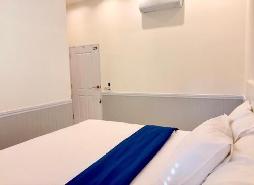 a bedroom with a white bed with a blue blanket at Koh Kood BED's in Ko Kood