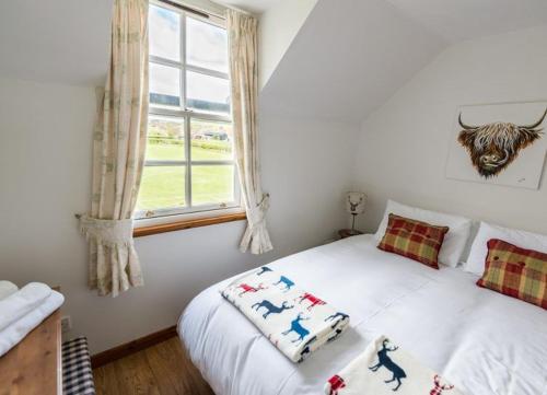 ein Schlafzimmer mit einem weißen Bett und einem Fenster in der Unterkunft Abbey Mill in Melrose