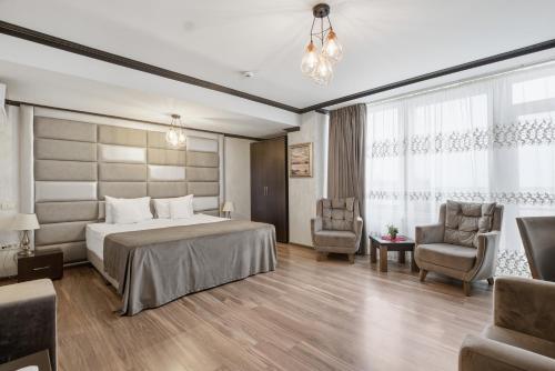 a hotel room with a bed and two chairs at Vila Reyna in Constanţa