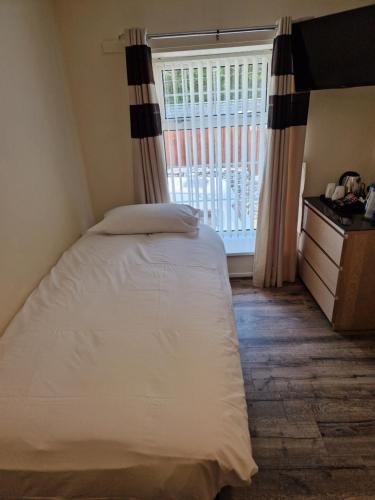 a bedroom with a bed and a window at Ynyscedwyn Arms in Ystradgynlais