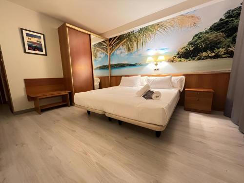 a bedroom with a bed with a painting on the wall at Cambrils Paradise in Cambrils