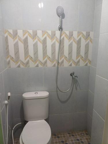 a bathroom with a toilet and a shower at Irma Guest House Syariah in Temenggungan