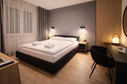 ein Hotelzimmer mit Bett und Schreibtisch in der Unterkunft FalHouse- luksusowe apartamenty z jacuzzi & sauna in Lesko