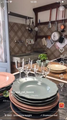 a table with plates and wine glasses on a counter at Agriturismo La Casa Nel Bosco in Boveglio