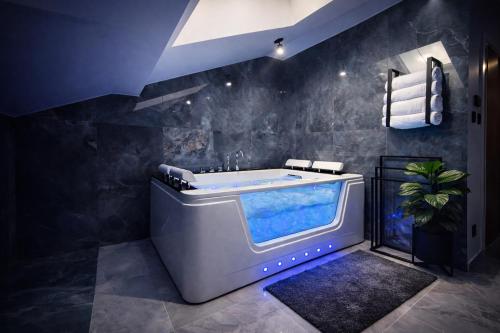 ein Badezimmer mit einer großen Badewanne in der Ecke in der Unterkunft FalHouse- luksusowe apartamenty z jacuzzi & sauna in Lesko