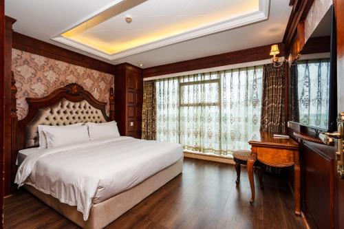 a bedroom with a bed and a desk and windows at 泽润大酒店 in Chengdu