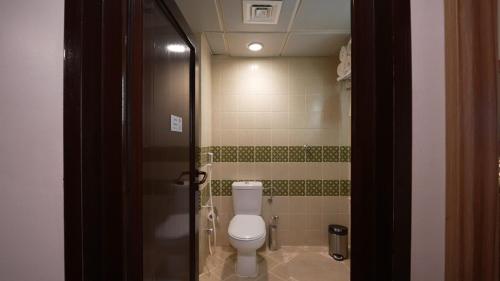 a bathroom with a white toilet in a room at ASTONEAST TAIBA Hotel in Medina