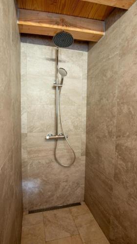 a shower with a shower head in a bathroom at Gîte de montredon in Cubières