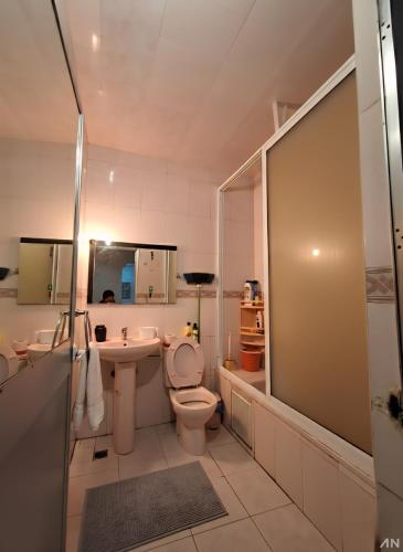 a bathroom with a toilet and a sink at Martil Beach Apartment in Martil