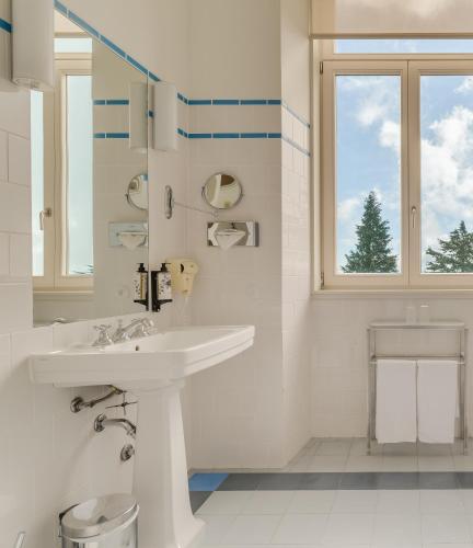 a white bathroom with a sink and a window at Pousada da Serra da Estrela in Covilhã