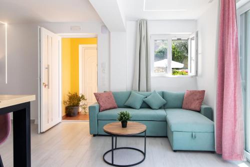 a living room with a blue couch and a table at The Olive Grove Cottage by Konnect - 2,5km from Ipsos in Ipsos