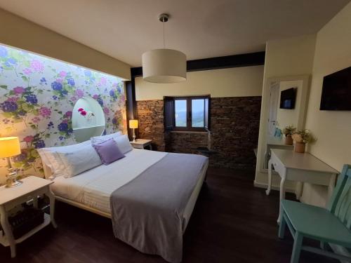 a bedroom with a bed and a wall with flowers at Campus Natura in Arganil