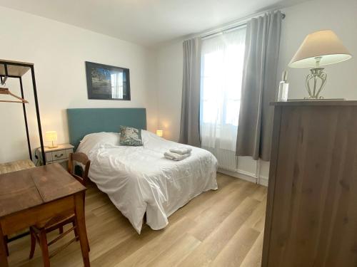 a bedroom with a bed and a desk and a window at Appartement proche Château de Compiègne in Compiègne