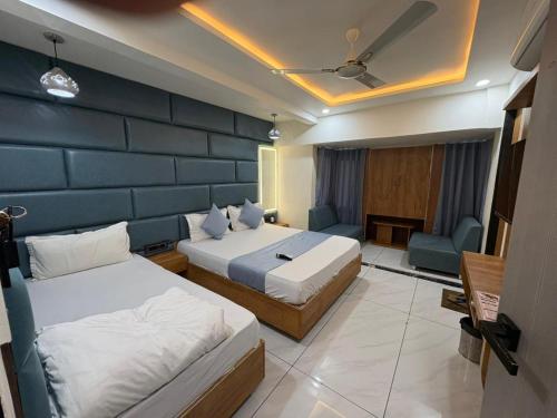 a bedroom with two beds and a blue wall at Hotel Skyland in Ahmedabad