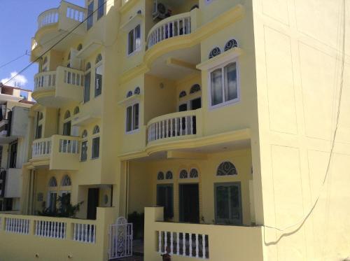 a large yellow building with white balconies at Seventh Heaven Inn Rishikesh in Rishīkesh