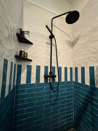 a bathroom with a shower with a blue tiled wall at Pythagorion Harbour Residence in Pythagoreio