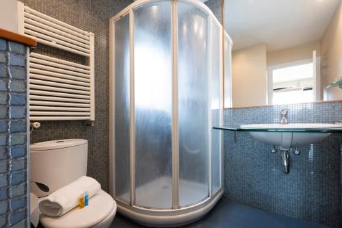 a bathroom with a shower and a toilet and a sink at Itsas aurre Basquenjoy in Fuenterrabía