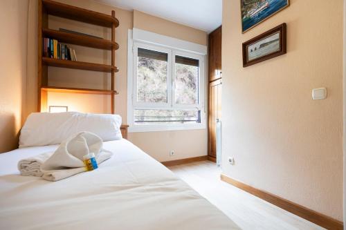 a bedroom with a white bed and a window at Itsas aurre Basquenjoy in Fuenterrabía