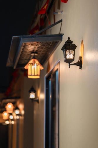 a group of lights on the side of a building at ThuAn Homestay Hoa Lư in Ða Gia