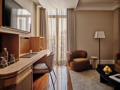 a living room with a desk and a chair in a room at Hotel Único Madrid, Small Luxury Hotels in Madrid