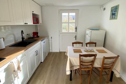a kitchen with a table with chairs and a refrigerator at Appartement proche Château de Compiègne in Compiègne