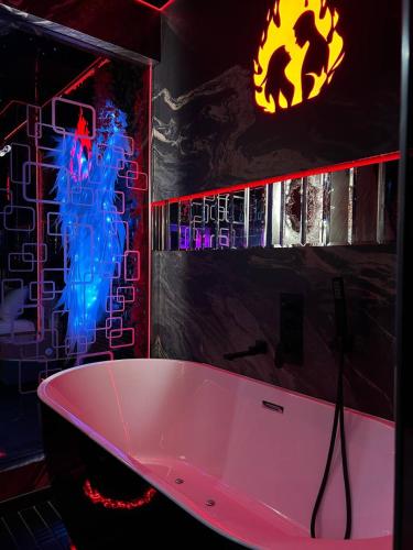 a bathroom with a bath tub and a batman sign at Angels Spa & Massage by Secret Apartaments in Gdańsk