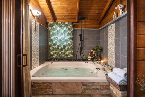a jacuzzi tub in a bathroom with a wooden ceiling at family cabin in Menaẖemya