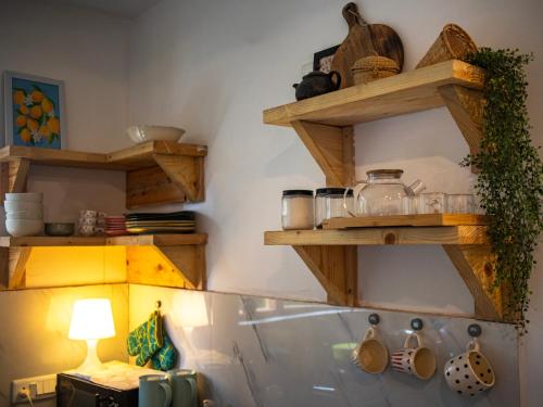 a kitchen with wooden shelves on the wall at Kuhama Private Mountain Chalet Naggar in Nagar