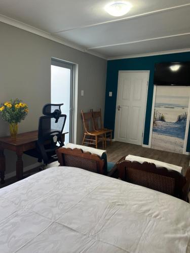 a bedroom with a bed and chairs and a table at Grace from Above in Malmesbury