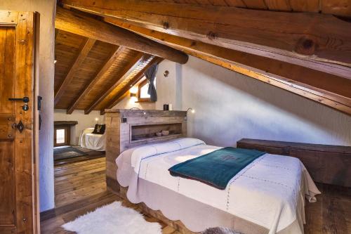 a bedroom with a bed in a room with wooden ceilings at Maison La Saxe in Courmayeur