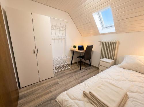 a bedroom with a bed and a desk with a laptop at Room4U in Memmingen