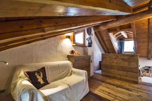a living room with a couch and wooden ceilings at Maison La Saxe in Courmayeur