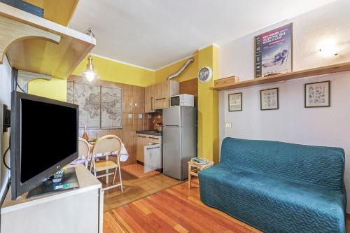 a living room with a blue couch and a kitchen at Grange Studio - Happy Rentals in Grange Sises