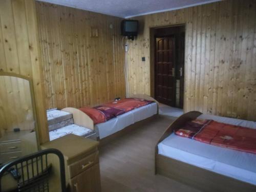 a room with three beds and a tv in it at Dudás panzió in Bükkszentkereszt