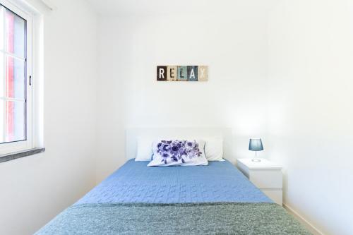 a bedroom with a bed with a blue bedspread at Picos House in Lajes do Pico