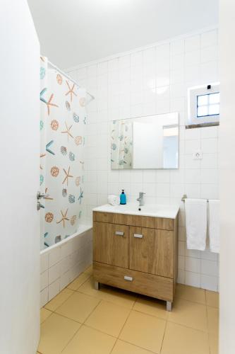a bathroom with a sink and a mirror at Picos House in Lajes do Pico