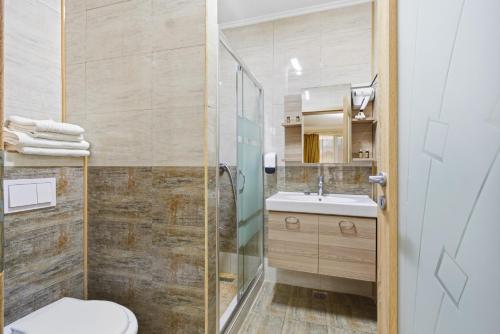 a bathroom with a shower and a toilet and a sink at REYNA APART HOTEL in Constanţa