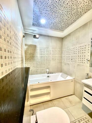 a bathroom with a tub and a toilet and a sink at The Premier Centauras in Islamabad