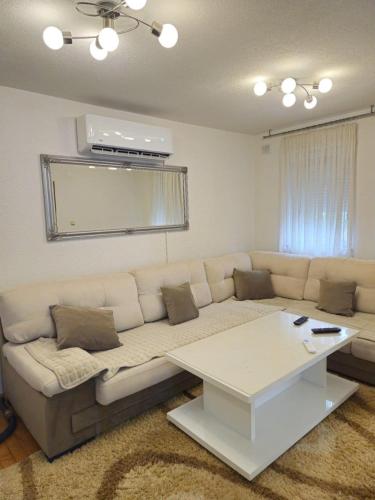 a living room with a white couch and a table at Vikendica Rujiste in Mostar